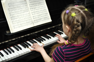 child plays on piano lesson of the music